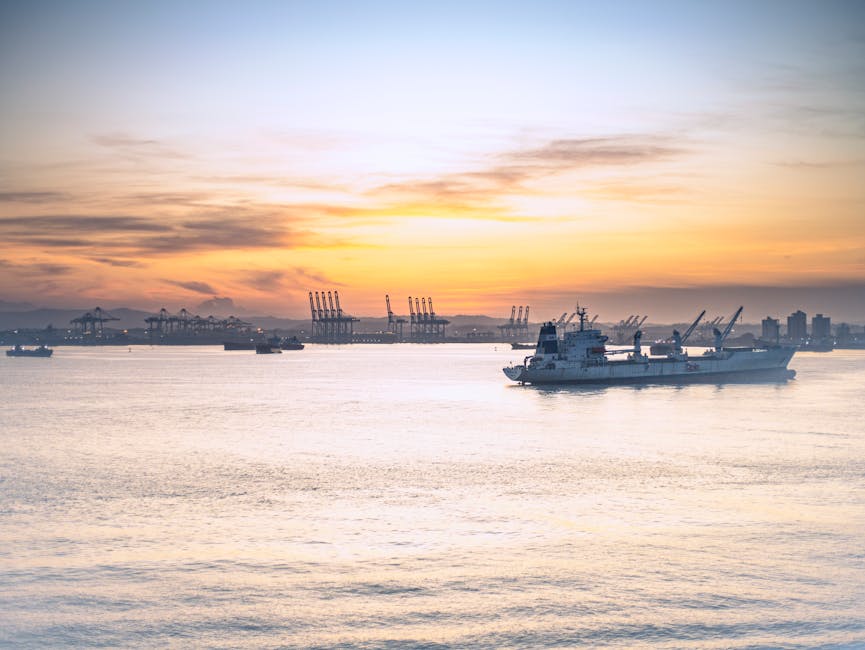 Calm waters reflect a stunning sunset at the Panama Canal port, showcasing industrial cranes and ships.